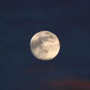 Beautiful full moon against a dark, cloudy night sky, offering a serene lunar view.